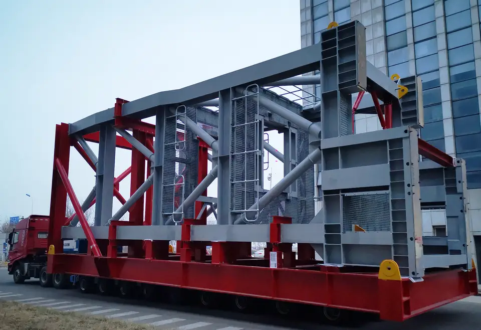 Red and grey steel mining frame loaded on a heavy transport trailer